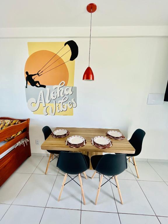 a dining room with a wooden table and chairs at Aloha Vibes Ap Cumbuco - Green Club in Cumbuco