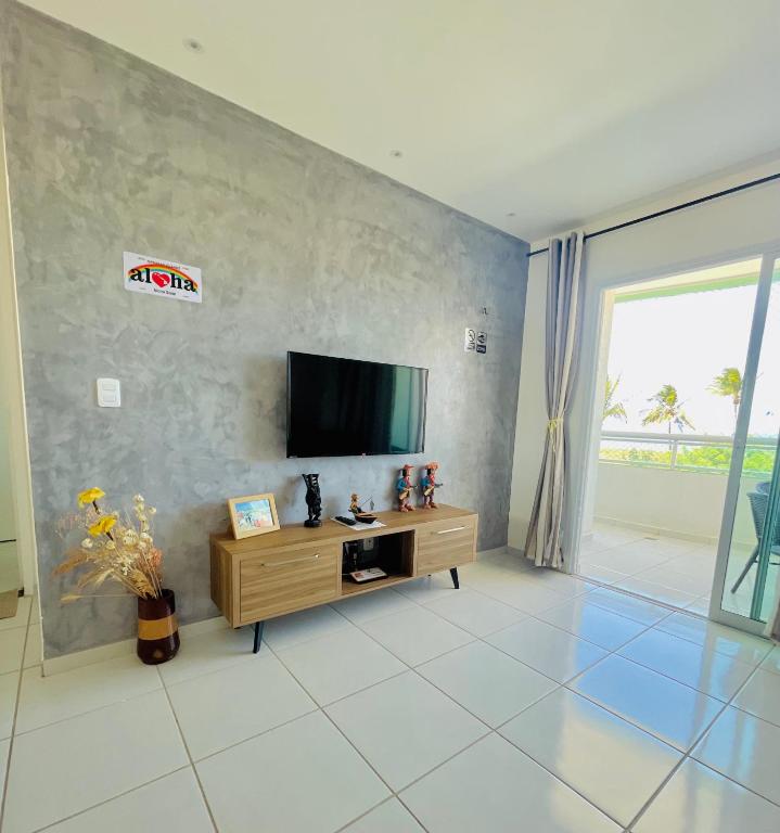 a living room with a flat screen tv on a wall at Aloha Vibes Ap Cumbuco - Green Club in Cumbuco