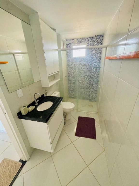 a white bathroom with a sink and a toilet at Aloha Vibes Ap Cumbuco - Green Club in Cumbuco