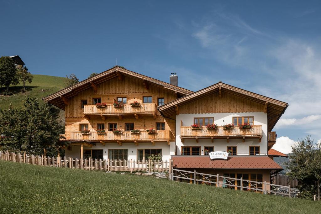 Una gran casa de madera con balcones en una colina en Der Erlenhof en Grossarl