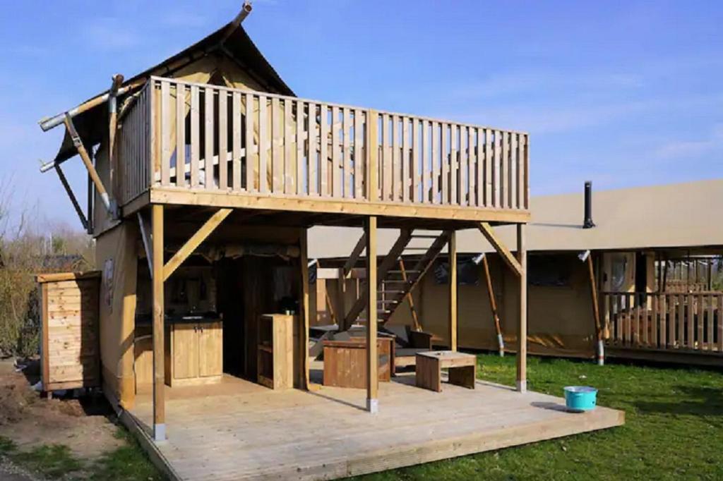 a large wooden house with a deck in the yard at Luxe en romantische overnachting voor 2 in Behelp