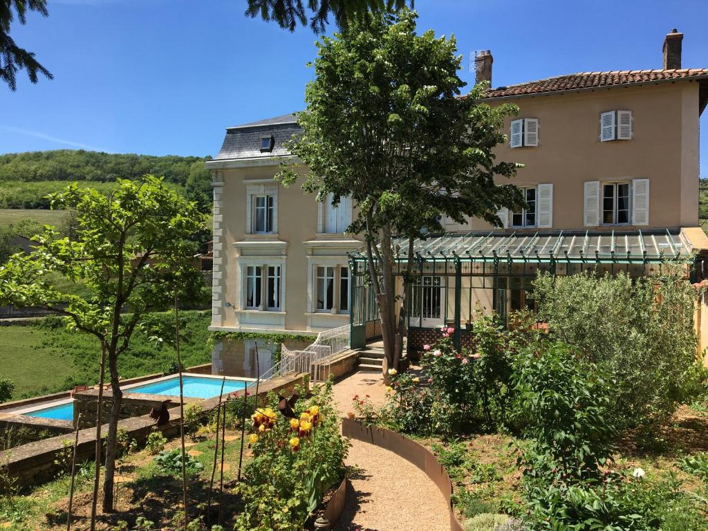 ein großes Haus mit Garten und Pool in der Unterkunft Le Clos des Fayettes in Theizé