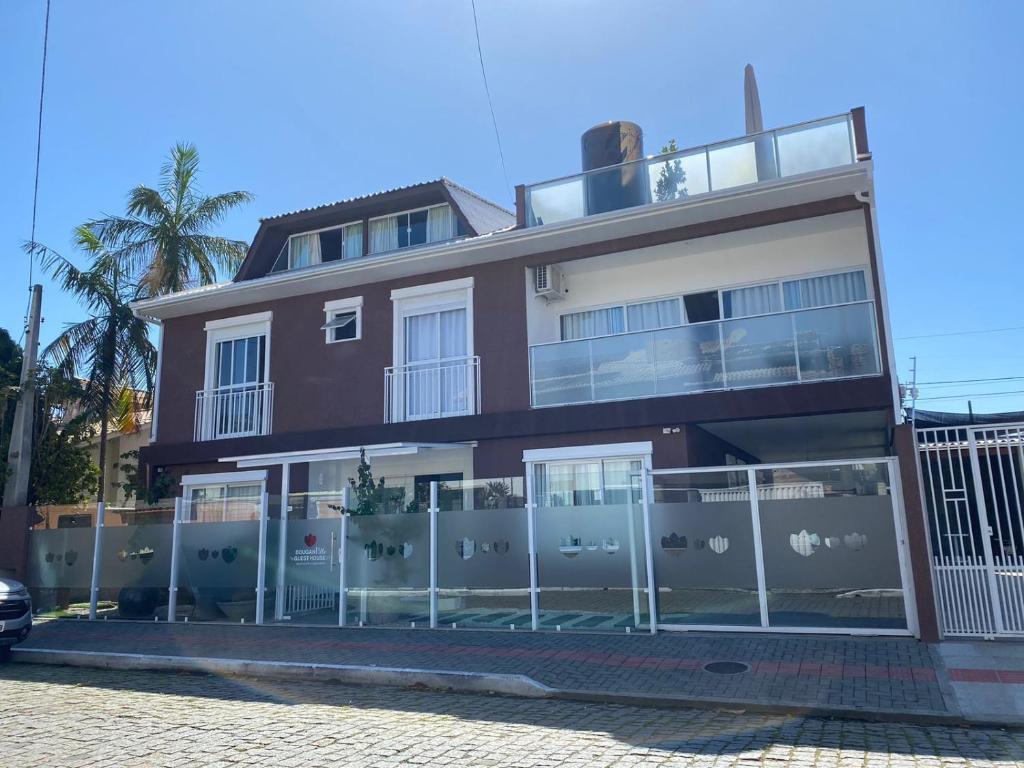 a house with a fence in front of it at Bouganville Guest House BC in Balneário Camboriú