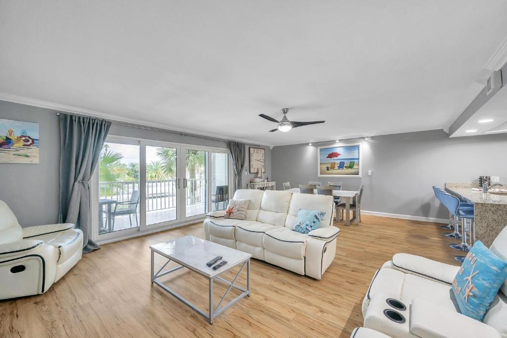 a living room with white furniture and a table at Holiday Villas 2 104 in Clearwater Beach