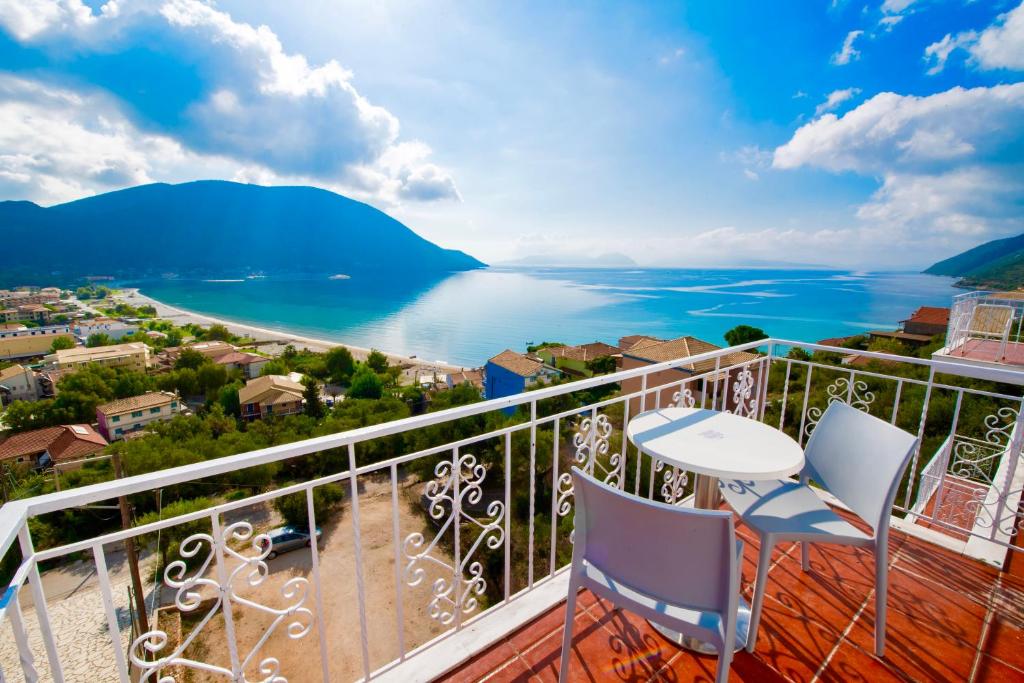 balcón con mesa, sillas y vistas al agua en Seaview Rooms, en Vasiliki