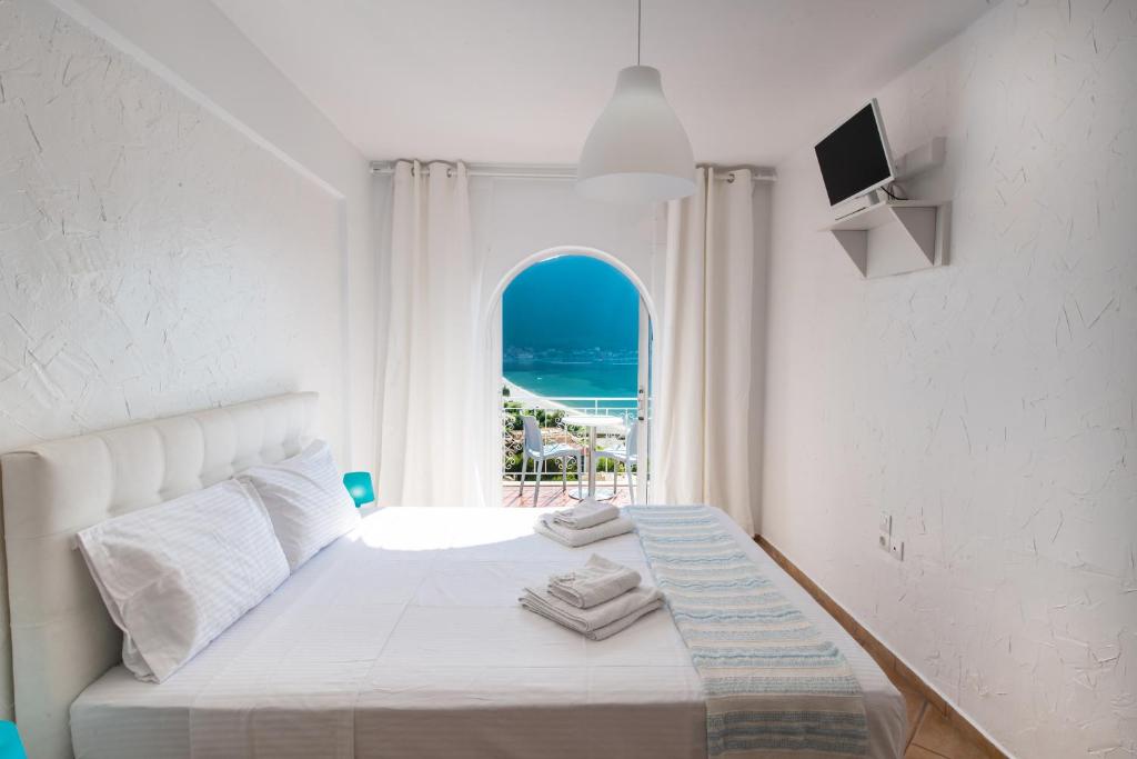 sypialnia z łóżkiem i widokiem na ocean w obiekcie Seaview Rooms w mieście Vasiliki