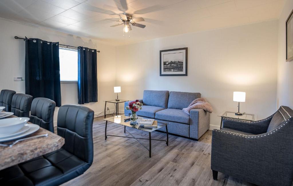 a living room with a blue couch and chairs at Downie Cottage by Revelstoke Vacations in Revelstoke