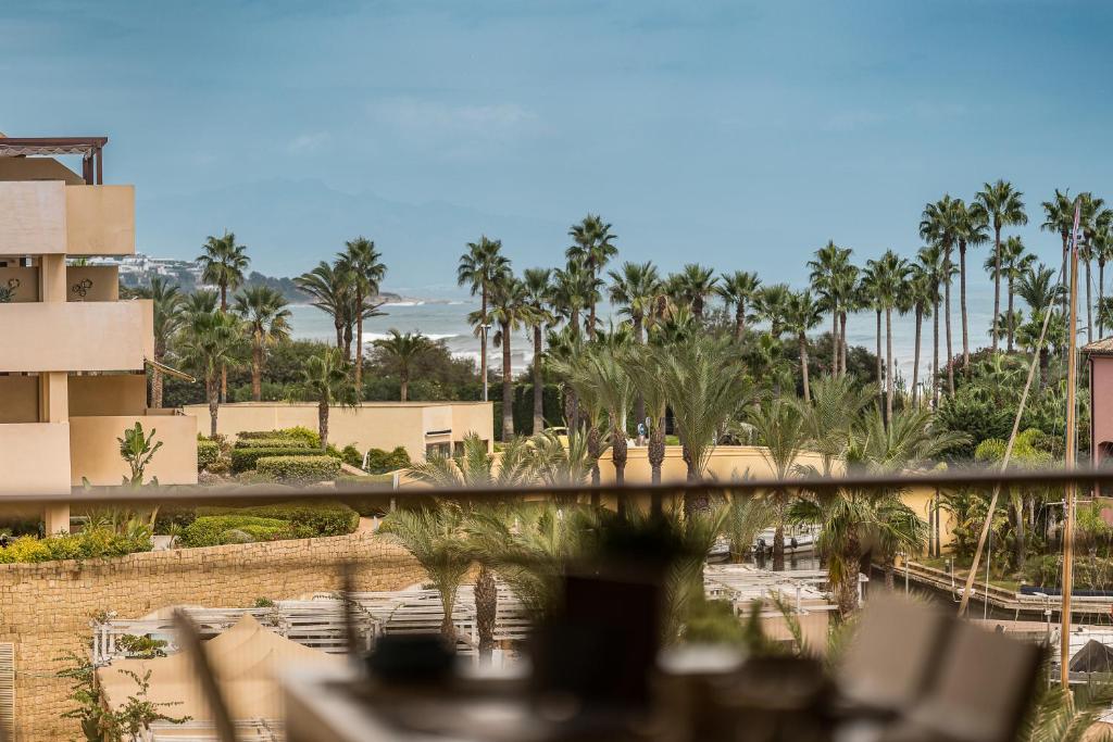 uma vista para um resort com palmeiras e o oceano em Sotogrande - Ribera del Marlín em Sotogrande