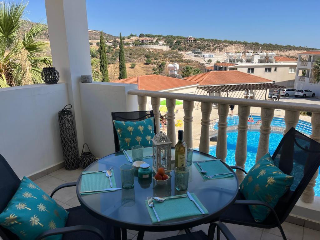 uma mesa numa varanda com vista para a piscina em Beautiful 2 Bed Apartment in Peyia Valley, Paphos em Peyia