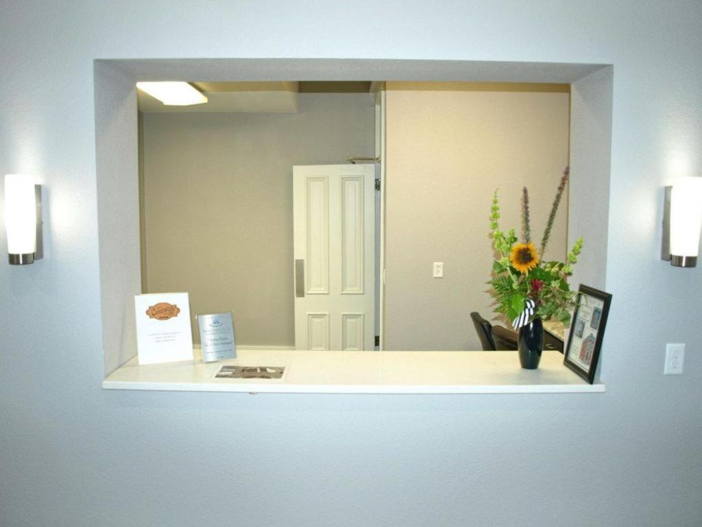 La salle de bains est pourvue d'un miroir et d'un lavabo avec un vase de fleurs. dans l'établissement Cornerstone Inn, à Washington