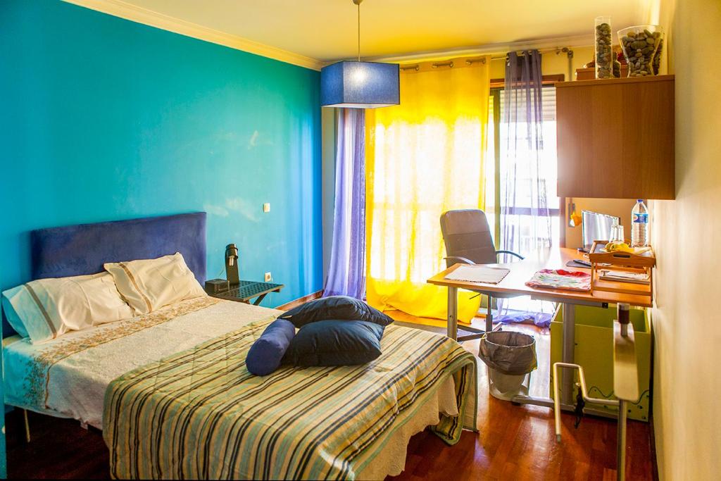 1 dormitorio con 1 cama y escritorio con ordenador portátil en Quarto junto ao mar, en Matosinhos