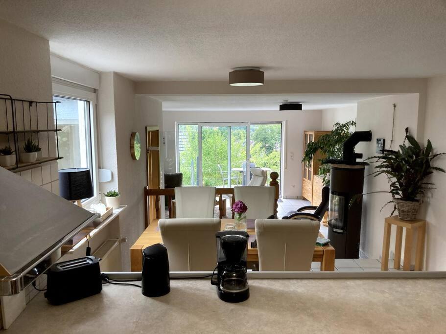 a living room with white chairs and a piano at SauerlandBlick in Altena