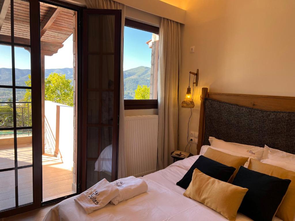 um quarto com uma cama e vista para uma varanda em Ski Suites - A Luxury Maisonette Kalavryta em Kalavrita