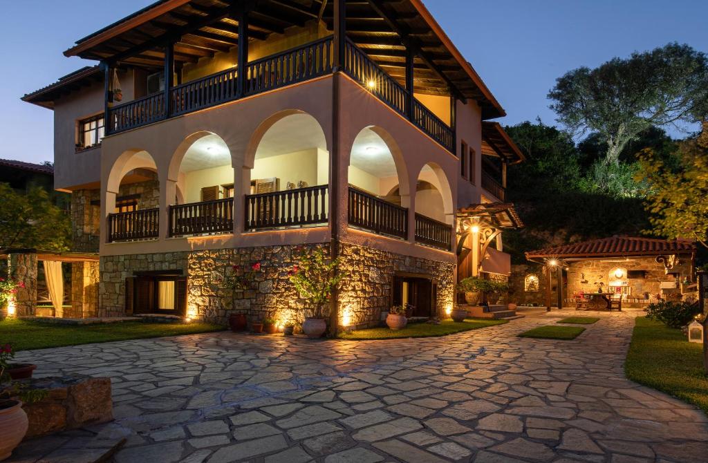 a large house with a stone driveway at Vetrinos Apartments in Ayios Nikolaos Sithonia