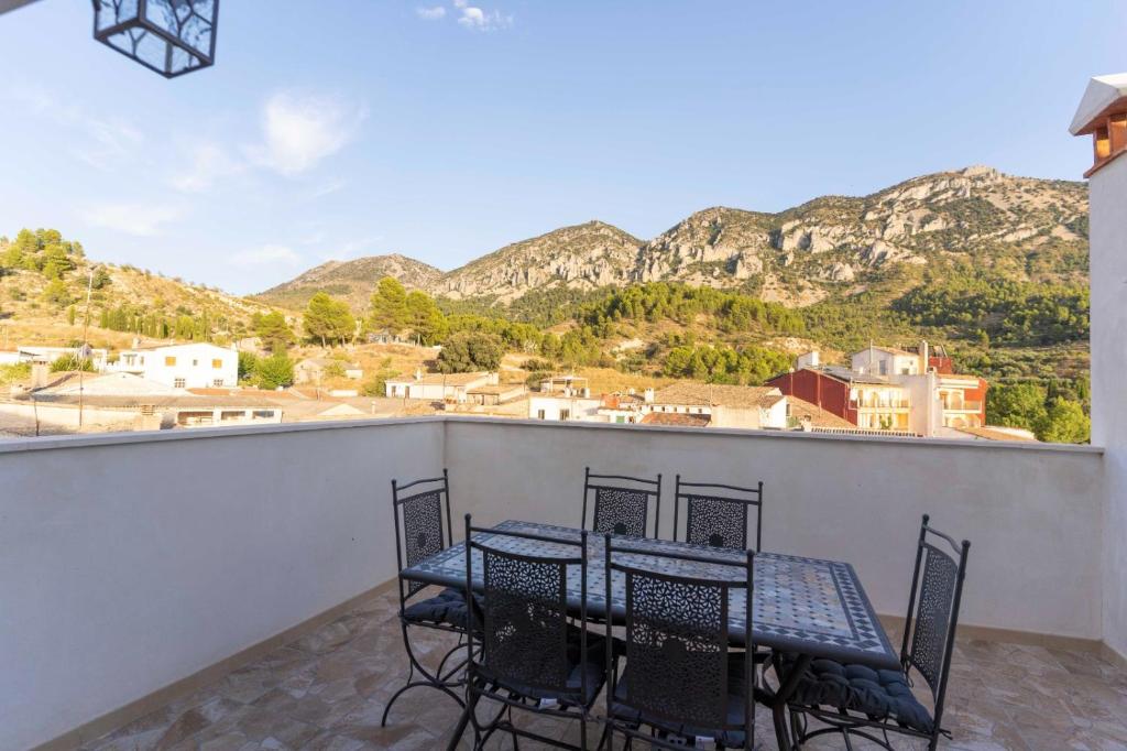 una mesa y sillas en un balcón con montañas en PLA DE LA CASA, en Cuatretondeta