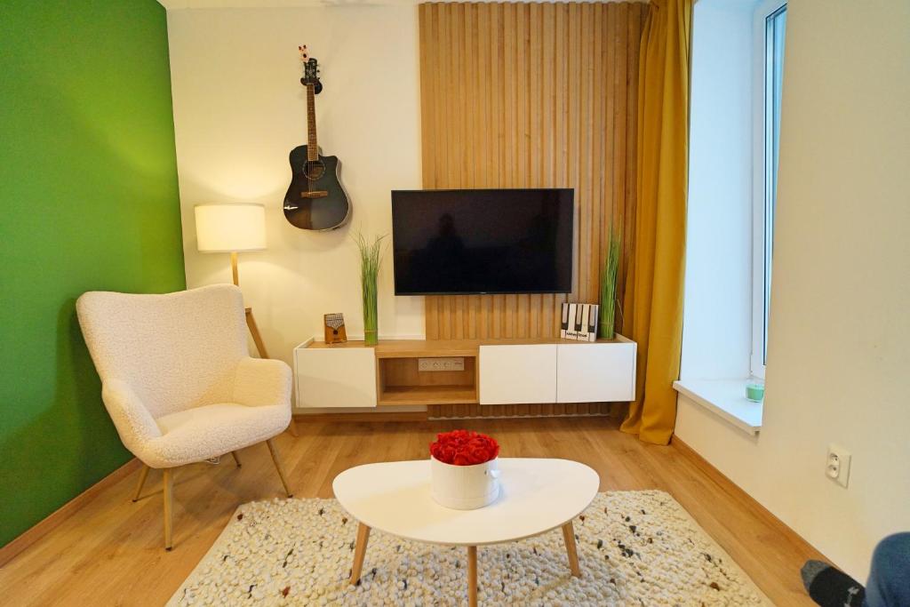 a living room with a television and a white table at Abbey Road Apartmán Iľanovo in Liptovský Mikuláš