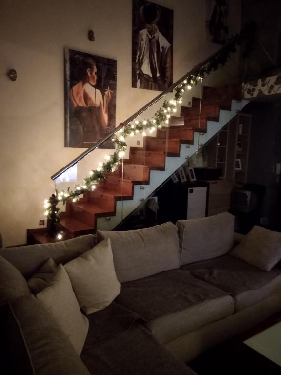 a living room with a couch and a staircase with lights at Lia Luxury home 2ΥΔ 110 τ μ in Chrysoupolis
