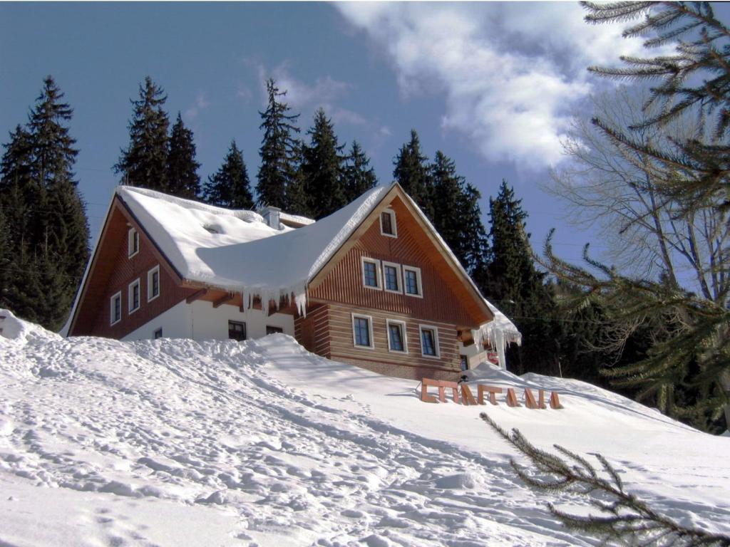 dom na śnieżnym wzgórzu ze śniegiem w obiekcie Pension Fontana w Szpindlerowym Młynie