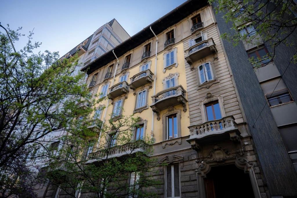 żółty budynek z balkonami na boku w obiekcie Loft in Stile Industrial - Stazione Centrale w Mediolanie