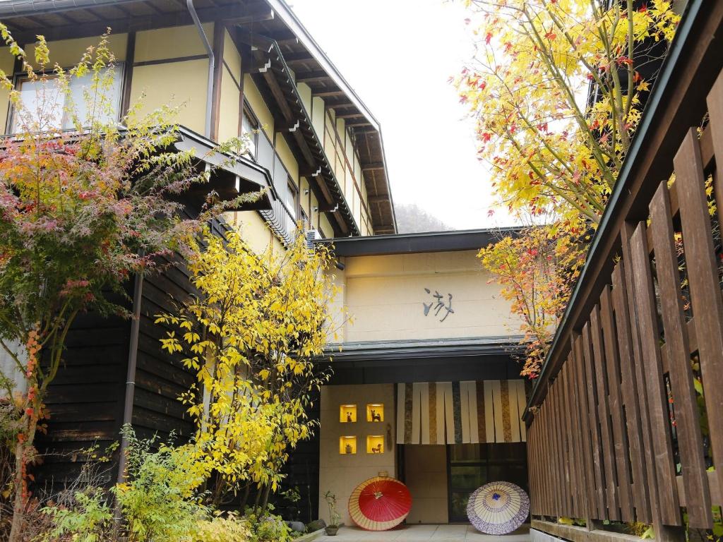 eine Außenansicht eines Gebäudes mit Bäumen in der Unterkunft Ryokan Kutsuroginoya Yuu in Takayama