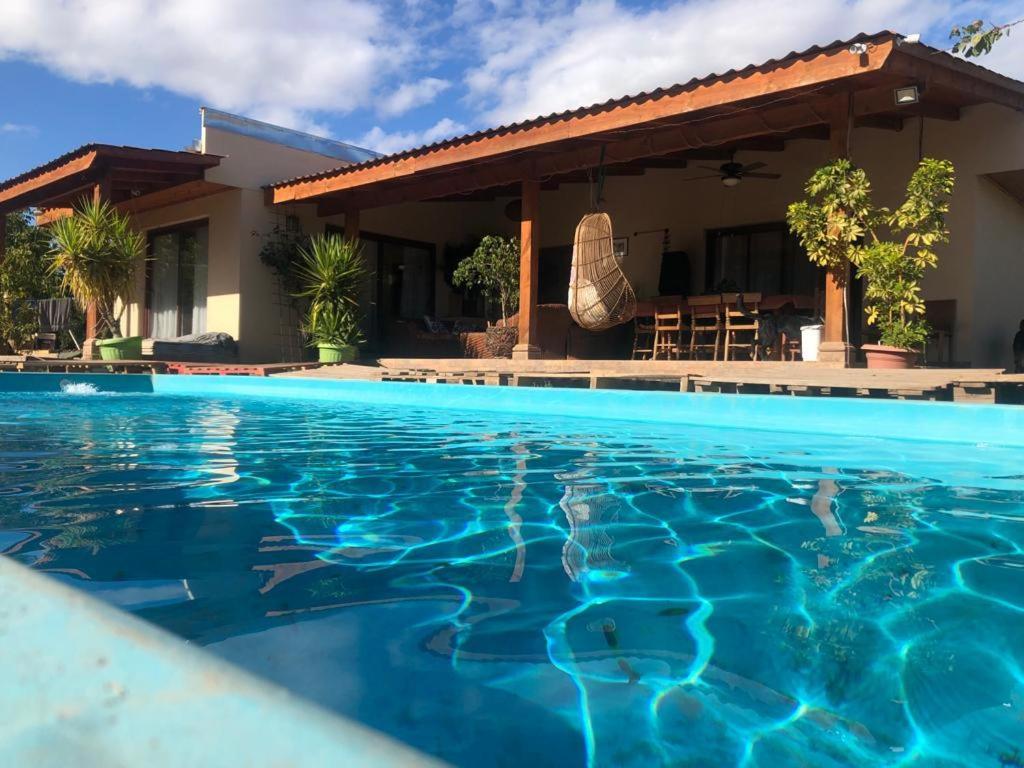 Villa con piscina frente a una casa en Alojamiento Los Nogales, en Santa Cruz