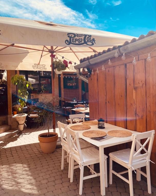 a table with chairs and an umbrella on a patio at Tar Pizza La Casa in Debrecen