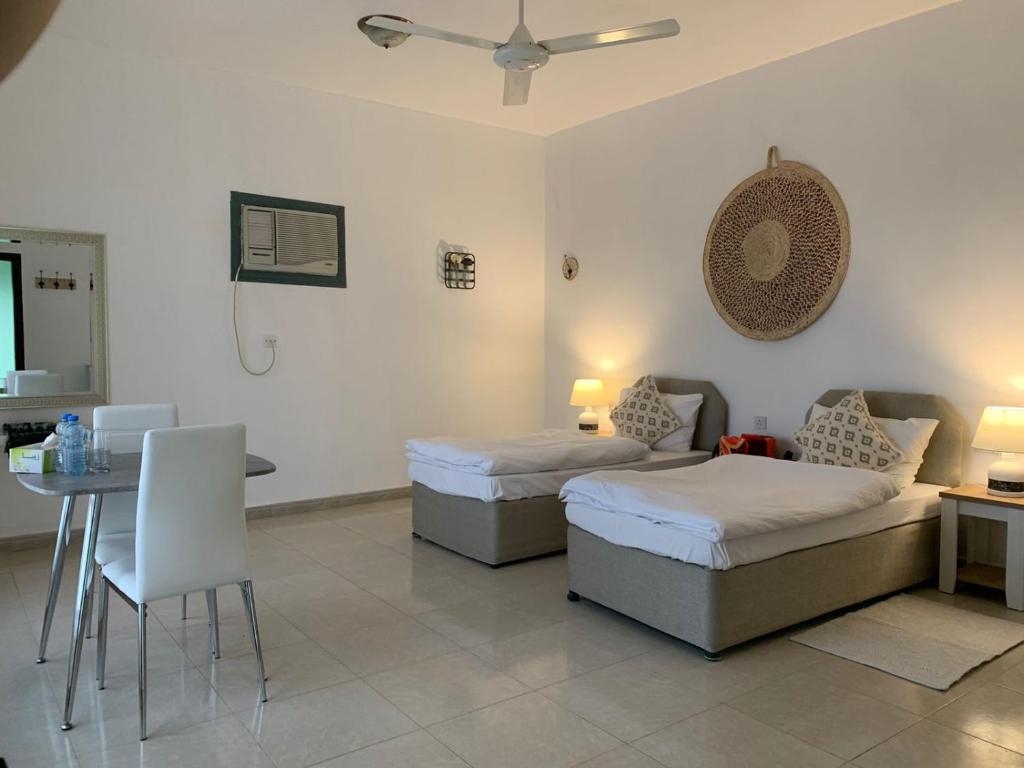 Habitación de hotel con 2 camas, mesa y comedor en Sunrise Resort Jebel Shams منتجع شروق الشمس جبل شمس, 