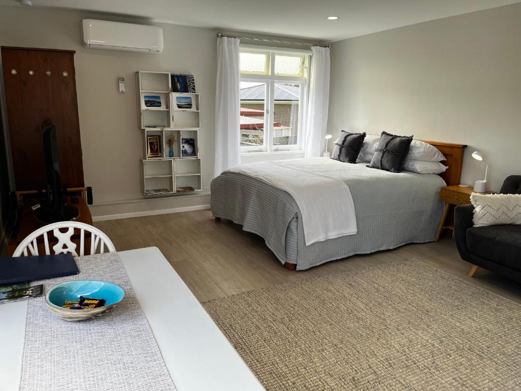 a bedroom with a bed and a living room at Raglan Retreat on Gilmour in Raglan