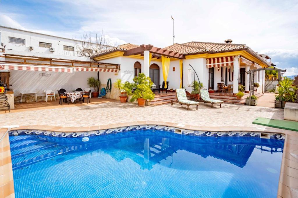 Villa con piscina frente a una casa en Casa Rural Can Petete en Padul