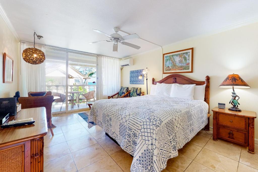 um quarto com uma cama, uma secretária e uma cadeira em Islander on the Beach 361 em Kapaa