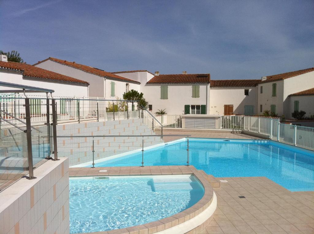 uma piscina em frente a uma casa em Studio "Palombe" dans résidence avec piscine em Saint-Martin-de-Ré