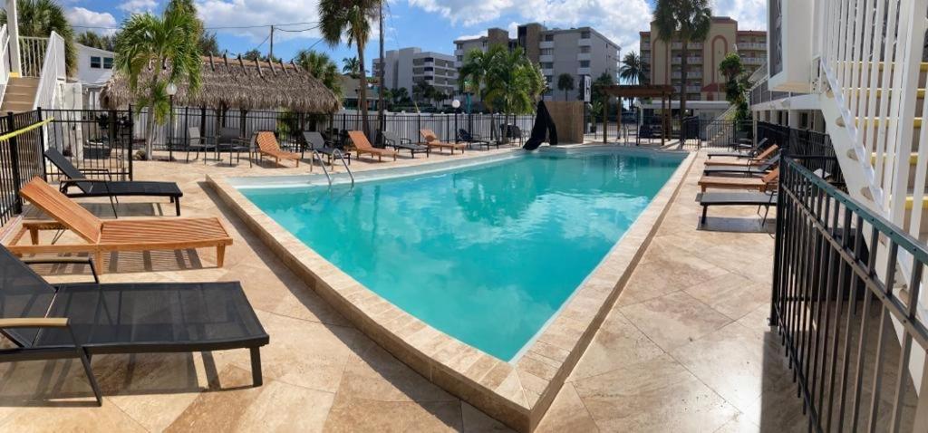 a swimming pool with lounge chairs and a hotel at Holiday Isles Resort in St Pete Beach