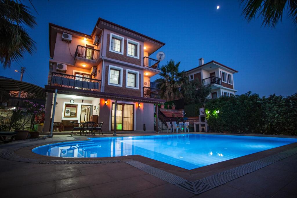 a house with a swimming pool in front of a house at Villa Ersak Ölüdeniz in Fethiye