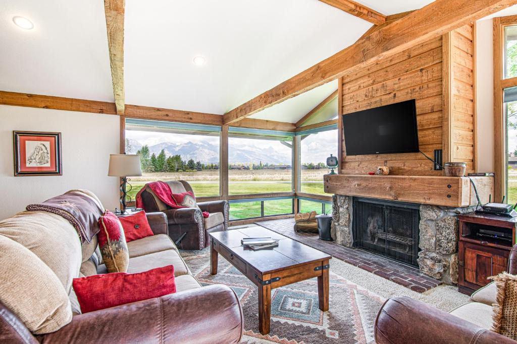 a living room with a fireplace and a tv at Golf Creek 32 in Teton Village