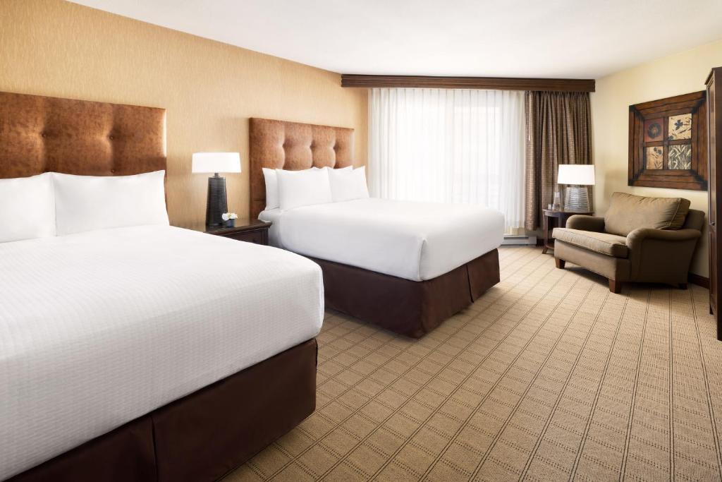 a hotel room with two beds and a chair at Elevation Hotel & Spa in Crested Butte