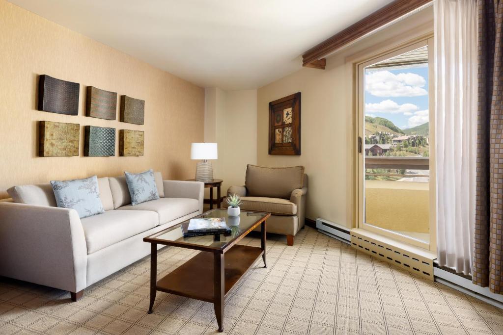 a living room with a couch and a table and a window at Elevation Hotel & Spa in Crested Butte