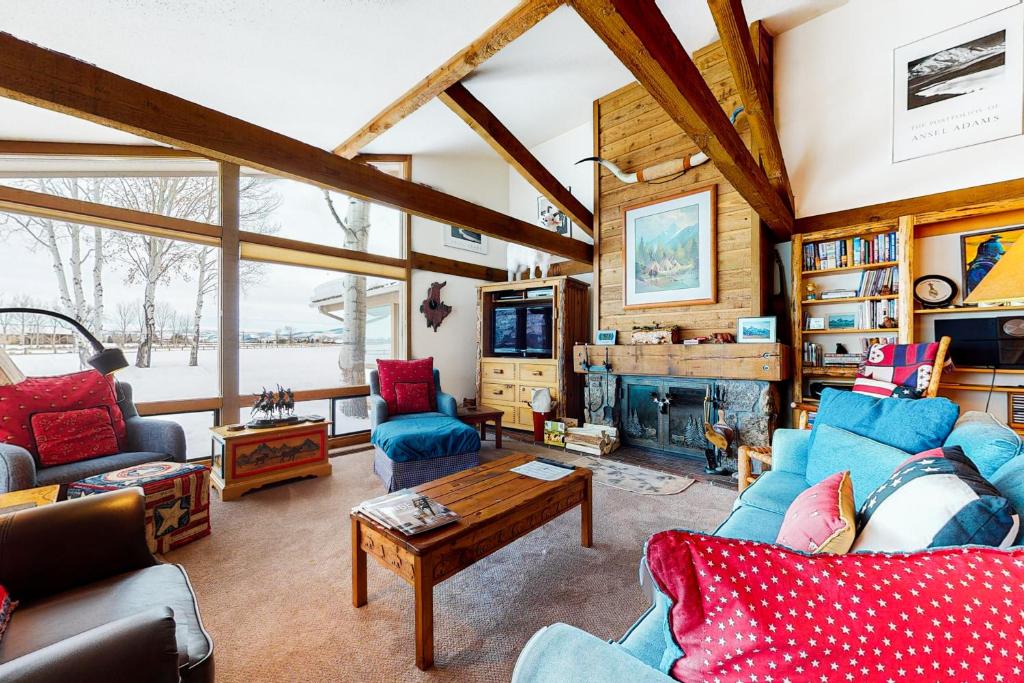 a living room with blue furniture and a fireplace at The Director's Cabin in Teton Village