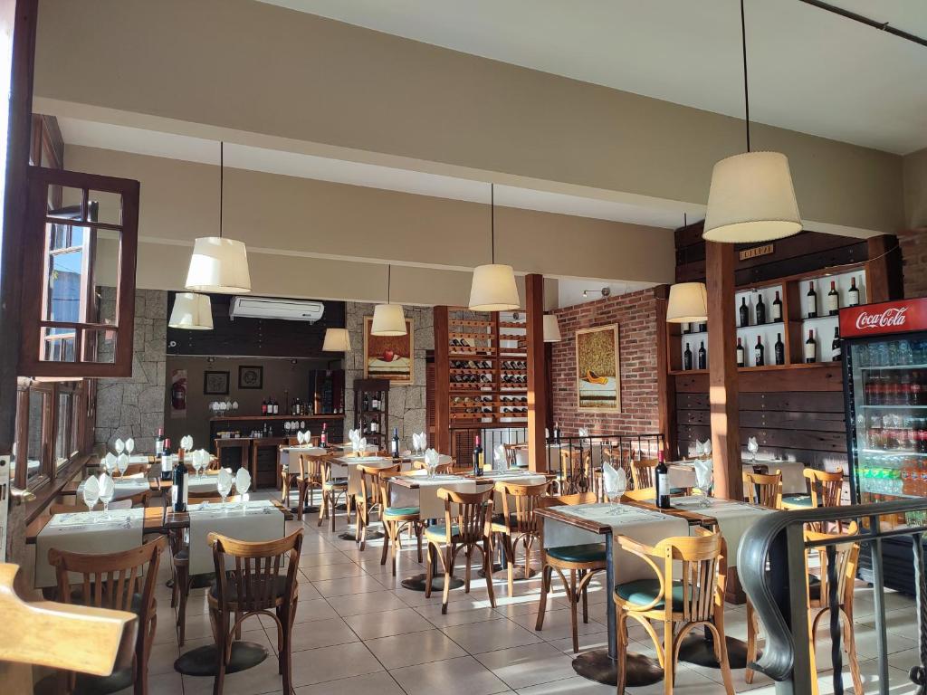Coronado Hotel في مينا كلافيرو: غرفة طعام مع طاولات وكراسي في مطعم
