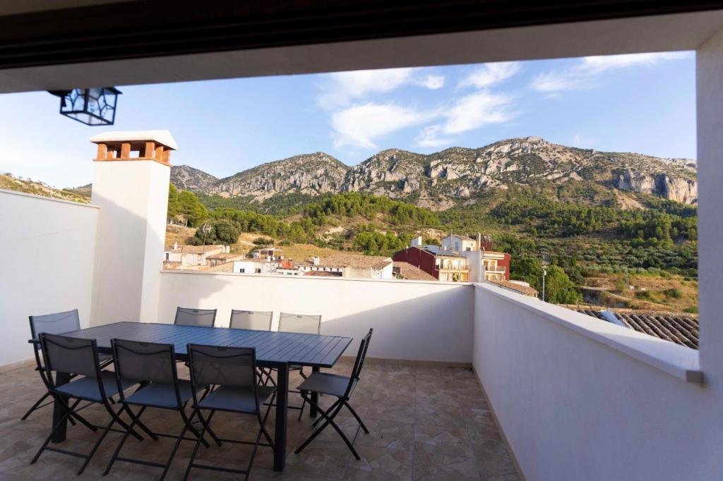 a table and chairs on a balcony with a view of mountains at CASA RURAL BIENVENIDA in Cuatretondeta