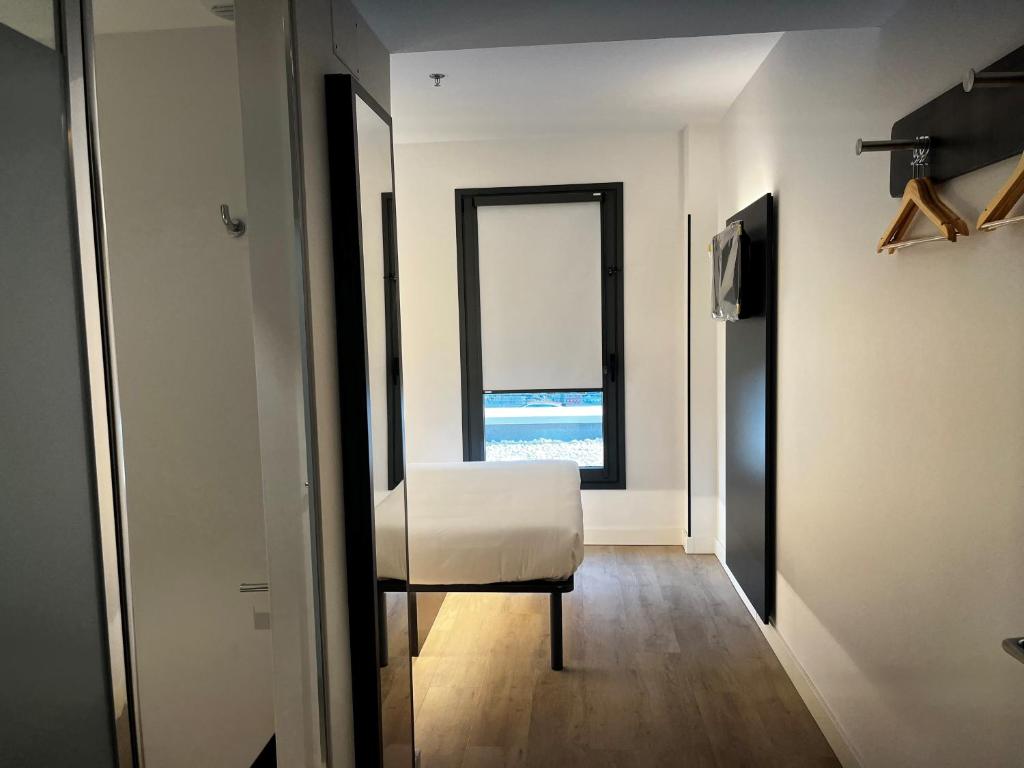 a room with a white chair and a window at Hs Madrid Centro Atocha in Madrid