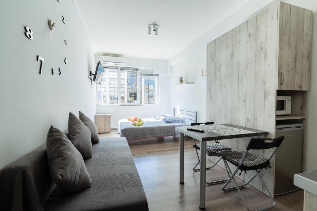 ein Wohnzimmer mit einem Sofa und einem Tisch in der Unterkunft Modiano Studio ΙΙΙ By Socrates Junior Houses in Thessaloniki