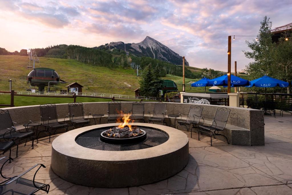 a fire pit in a patio with a mountain in the background at Elevation Hotel & Spa in Crested Butte