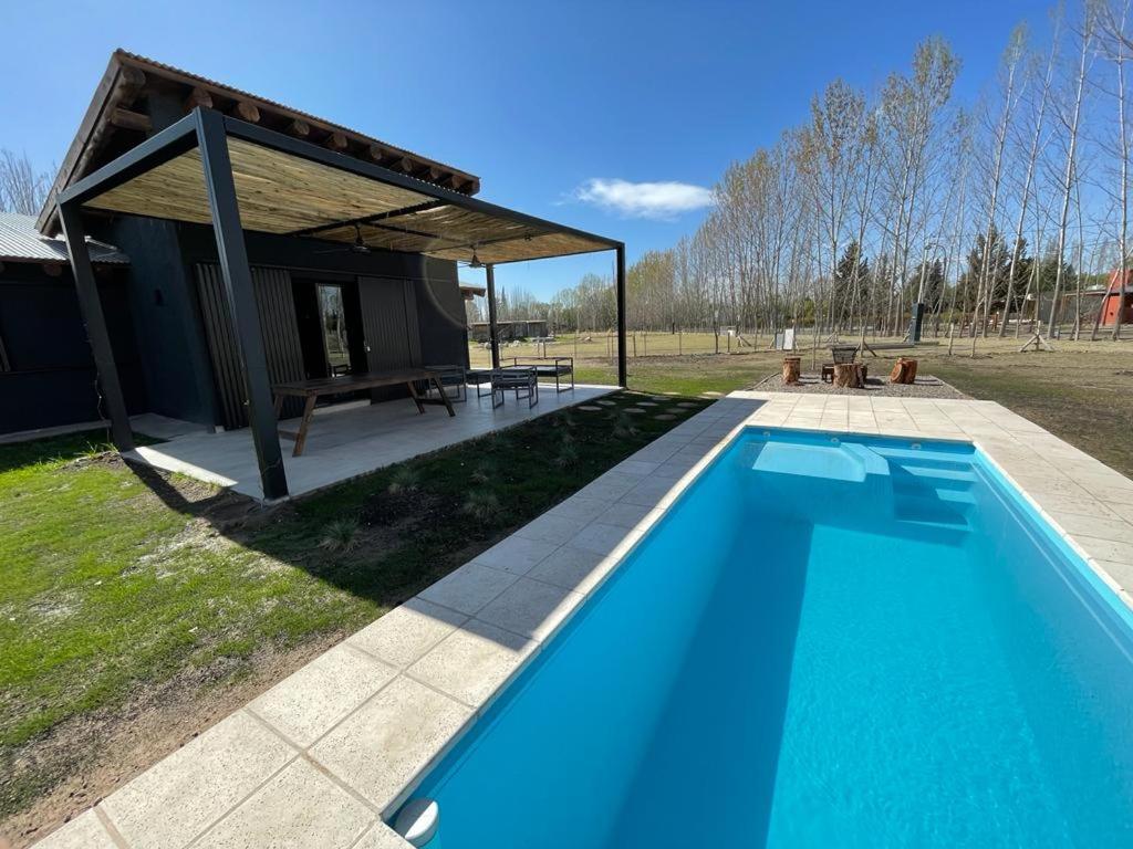 a large blue swimming pool in front of a building at Casa Julia, Tunuyán in Colonia Las Rosas