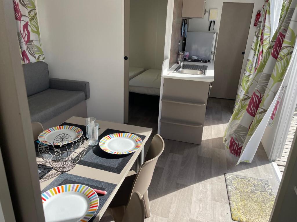 una pequeña habitación con una mesa con platos. en FILEAUX 323, en Litteau