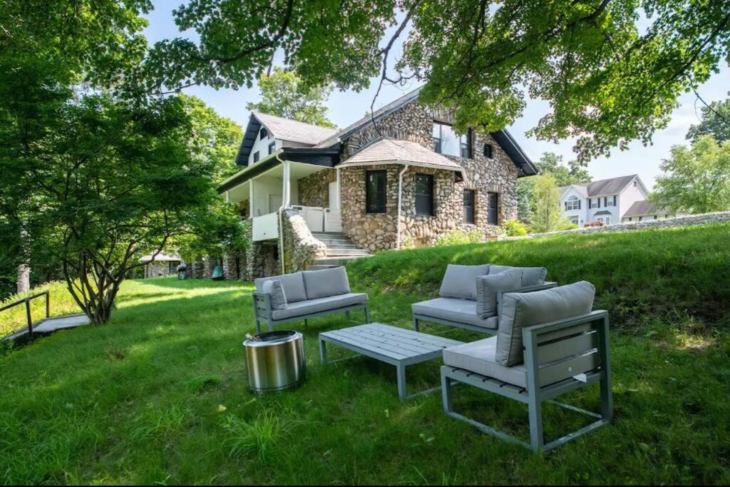 un patio con 2 sillas y una mesa frente a una casa en Incredible Ranch in the Woods - Lake View - Peace and Luxury! en Monroe