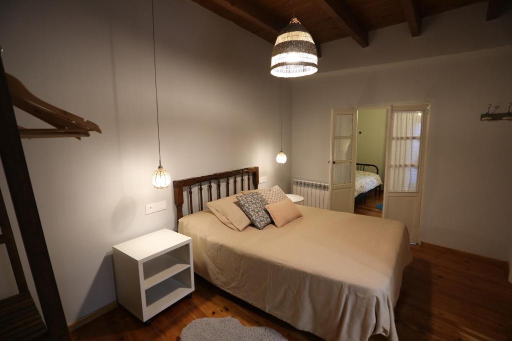 a bedroom with a large bed and a lamp at Casa Rural La Chiquitita in Alaejos