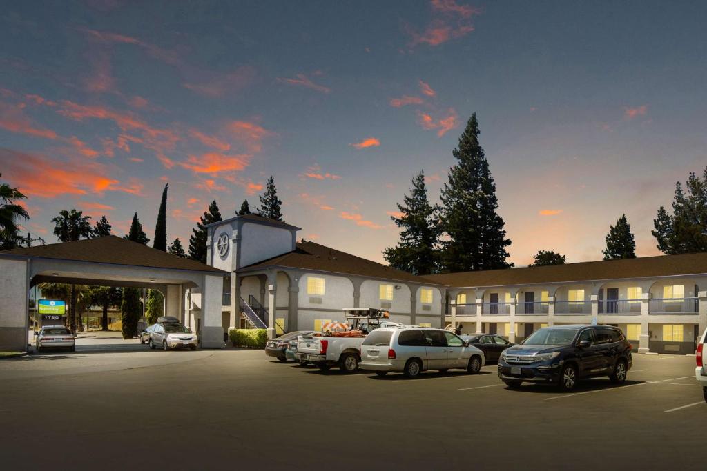 a large building with cars parked in a parking lot at SureStay Hotel by Best Western Ukiah in Ukiah