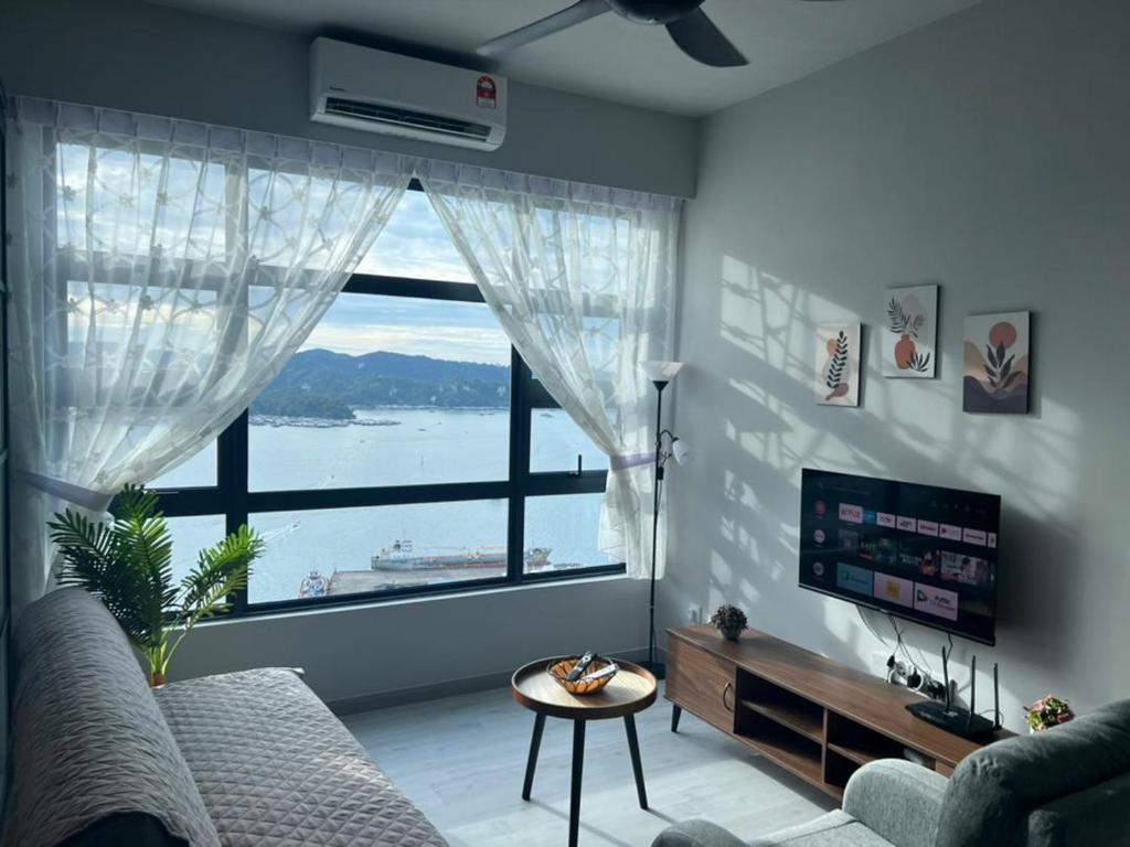 a living room with a large window and a couch at Jesselton Quay Seaview Homestay with free 1 parking by StayPlace in Kota Kinabalu