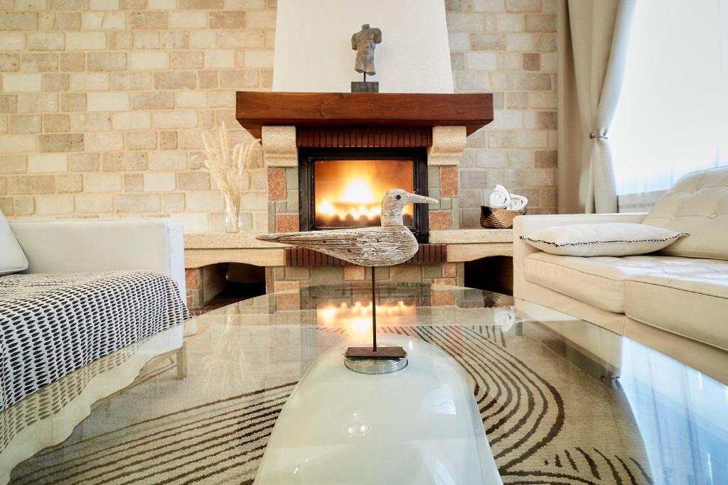 una sala de estar con chimenea y una estatua de un pato en VILLA SANDERLING au cœur de Saint Valery Haut standing 5 étoiles, en Saint-Valery-sur-Somme