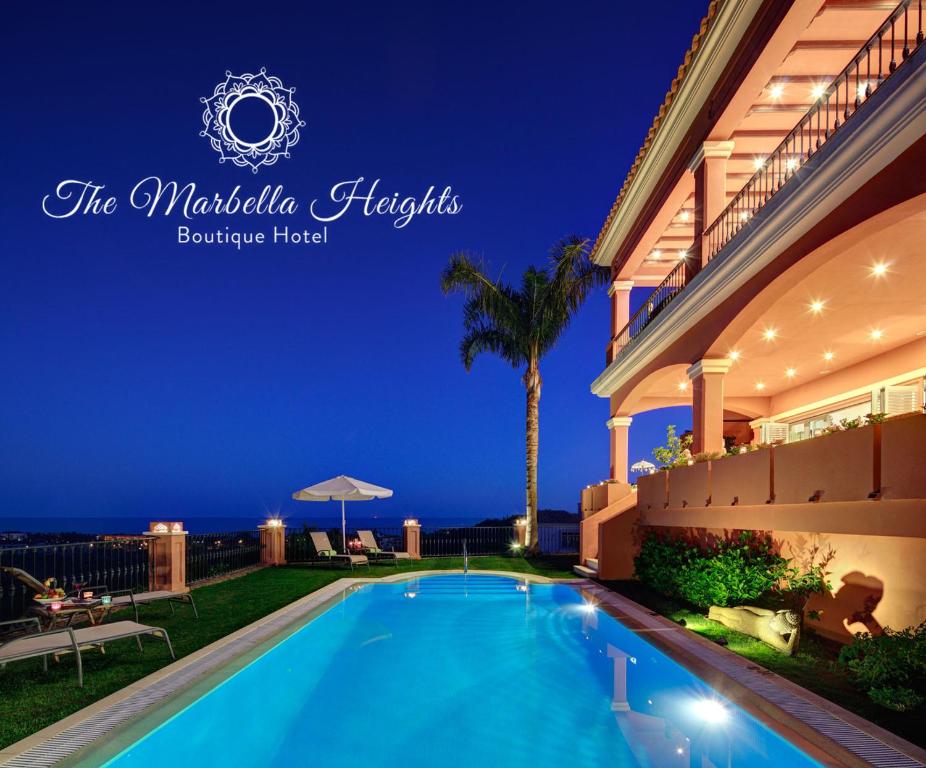 a swimming pool in front of a house at night at The Marbella Heights Boutique Hotel in Marbella